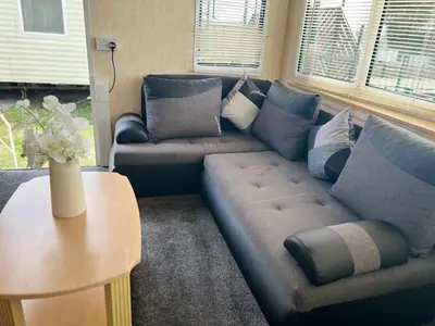 a living room with a couch and a table at Rohannah A&C Ultimate Caravan Retreat in East Mersea