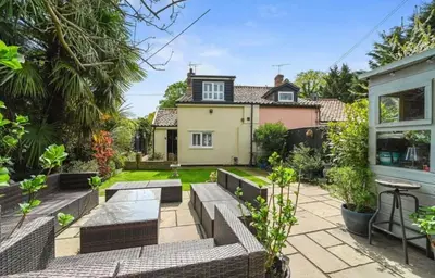 a home with a patio and a house at A Beautiful Country Cottage in Waldringfield