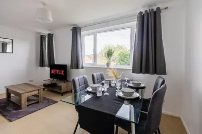 a dining room with a black table and chairs at Cambridge House near Addenbrookes, station and parking! in Shelford