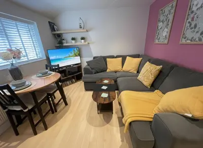 a living room with a couch and a table at Stylish 2 bed apartment - easy walk to Addenbrookes in Cambridge