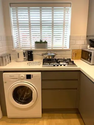 a kitchen with a stove and a washing machine at Stylish 2 bed apartment - easy walk to Addenbrookes in Cambridge