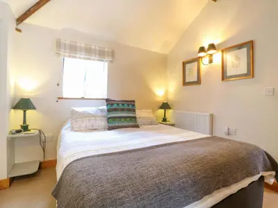 a bedroom with a large bed and a window at The Kiln in Harleston