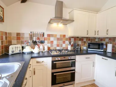 a kitchen with a sink and a stove top oven at The Golden Cross in Harleston