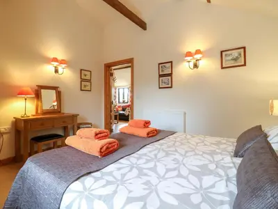 a bedroom with a bed and a desk and a mirror at The Golden Cross in Harleston