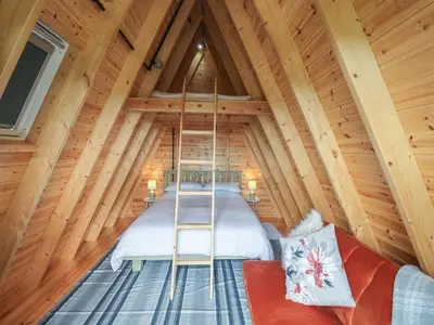 a room in a log cabin with a ladder in it at Robin in Woodbridge