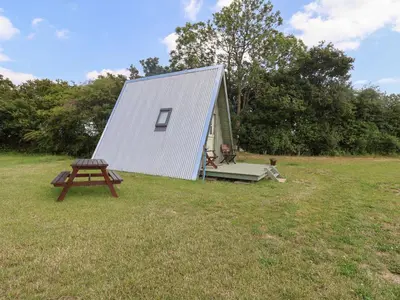 a small tent with a picnic table in a field at Robin in Woodbridge