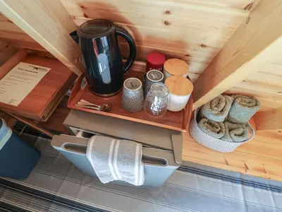 a shelf in a cabin with a coffee maker and towels at Robin in Woodbridge