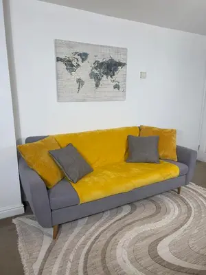 a couch with a yellow blanket in a room at Long Stay Basildon Essex Business Contractors in Basildon