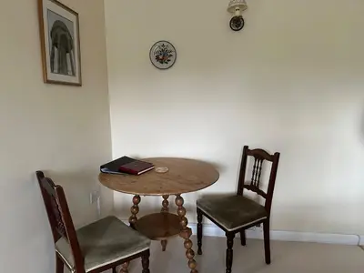 a wooden table with two chairs and a book on it at Little Furrows, Wenhaston in Wenhaston