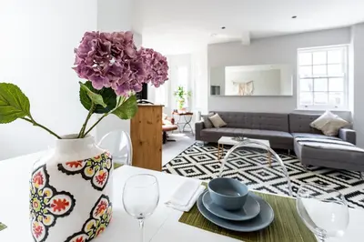 a living room with a vase with purple flowers on a table at 2BR Apartments in Southend near City Centre in Southend-on-Sea