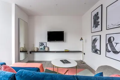 a living room with a blue couch and a tv at 2BR Apartments in Southend near City Centre in Southend-on-Sea
