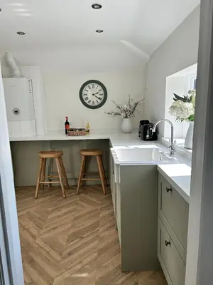 a kitchen with a sink and a clock on the wall at Historic Retreat Near To Mersea Island in Peldon