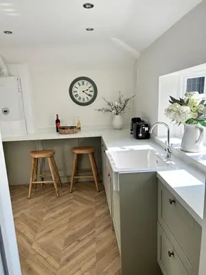 a kitchen with a sink and a clock on the wall at Historic Retreat Near To Mersea Island in Peldon
