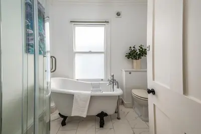 a white bathroom with a tub and a toilet at Elegant Period House in the Historic Heart of Cambridge - sleeps 12 in Cambridge