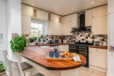 a kitchen with a wooden counter top with a tray of food at Elegant Period House in the Historic Heart of Cambridge - sleeps 12 in Cambridge