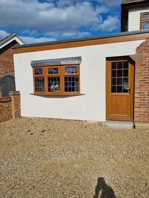 a detached house with a wooden door and windows at Cozy Studio Newly Furnished in Colchester