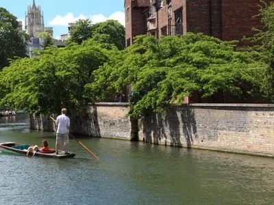 a man is rowing a boat on a river at CB Stays - 2 Bedroom & 2 Toilet Flat - Near Mills Road and Train Station with Parking in Cambridge