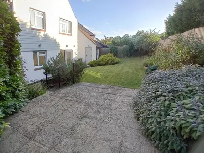 a yard with a white house and a garden at 'Ks' Yard in Great Dunmow