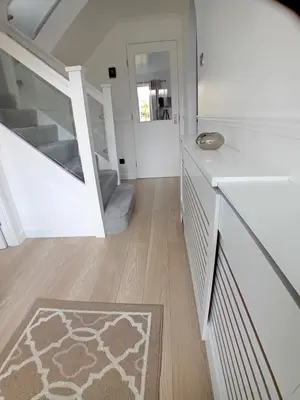 a white room with a staircase and a rug at 'Ks' Yard in Great Dunmow