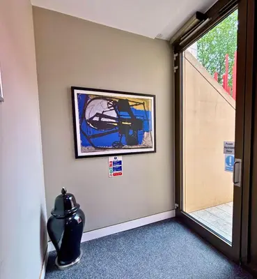 a hallway with a painting on the wall next to a door at Modern Central Apartment with Parking in Cambridge
