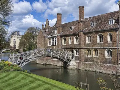 a bridge over a river in front of a building at Modern Central Apartment with Parking in Cambridge