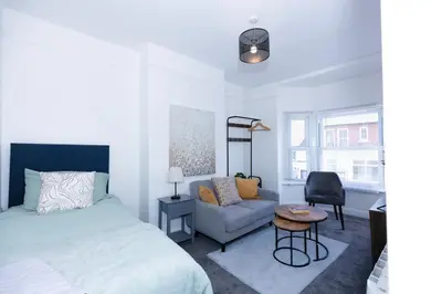 a bedroom with a bed and a chair and a desk at Urban Escape - Flat in Brandon