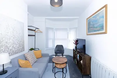 a living room with a blue couch and a table at Urban Escape - Flat in Brandon