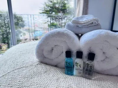 a bed with a pile of towels and two bottles of soap at Pacific Hotel in Clacton-on-Sea
