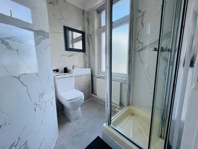 a bathroom with a toilet and a glass shower at Pacific Hotel in Clacton-on-Sea