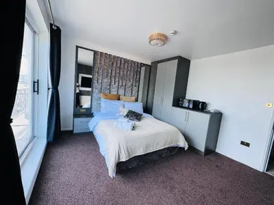 a bedroom with a bed and a large window at Pacific Hotel in Clacton-on-Sea