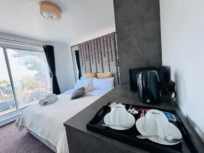 a hotel room with a bed with plates on a tray at Pacific Hotel in Clacton-on-Sea