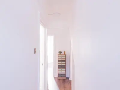 a white hallway with a dresser and a window at Pass the Keys Comfortable Flat with Patio Sleeps 4 in Westcliff On Sea