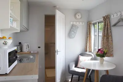 a kitchen with a table and a small table and a table at Unique Suffolk Cabin with Countryside Views in Burgh