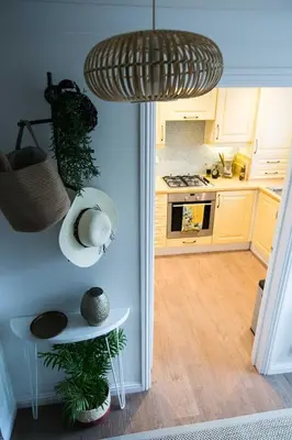 a kitchen with white cabinets and a table with plants at Your home away from home in Bury Saint Edmunds