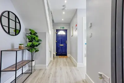 a hallway with a blue door and a plant at 5 Bedroom Apartment - Weekly Deal - By Homestyles Hosts Short Lets and Serviced Accommodation Widford - Free Parking in Writtle