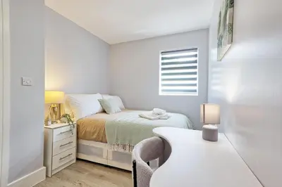 a white bedroom with a bed and a desk at 5 Bedroom Apartment - Weekly Deal - By Homestyles Hosts Short Lets and Serviced Accommodation Widford - Free Parking in Writtle