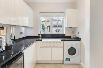 a white kitchen with a washer and dryer at Relaxing Coastal Getaway Perfect for Families in Canvey Island