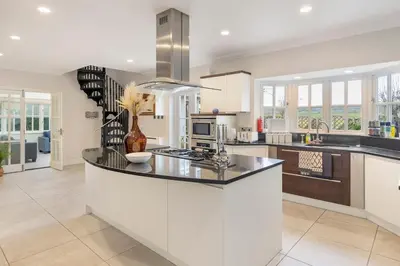 a kitchen with white cabinets and a counter top at Relaxing Coastal Getaway Perfect for Families in Canvey Island