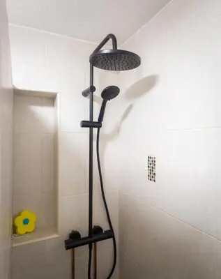 a shower with a shower head in a bathroom at Lazy Acre, Suffolk in Hopton