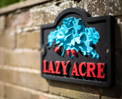 a sign on a brick wall with a law agency sign at Lazy Acre, Suffolk in Hopton