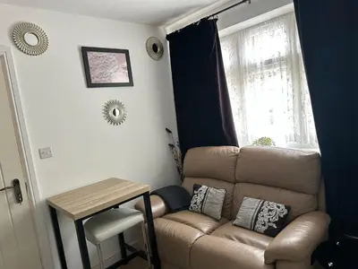 a living room with a couch and a table at A Comfortable and Cosy Self Contained Room in Navestock