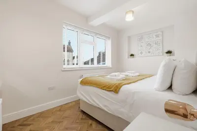 a white bedroom with a large bed and a window at 2 Royal Serviced Apartments, Ground Floor, two Bed,Fast Wifi - Space in Parkeston