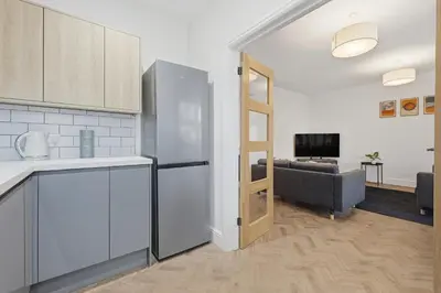a kitchen with a refrigerator and a living room at 2 Royal Serviced Apartments, Ground Floor, two Bed,Fast Wifi - Space in Parkeston
