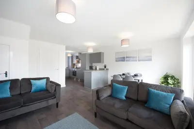 a living room with two couches and a kitchen at House -Superking Beds-Garden-FastWifi-Pet Friendly in Broomfield