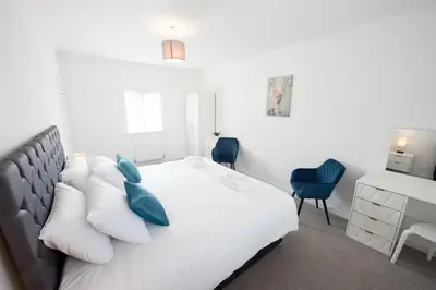 a bedroom with a white bed with blue pillows at House -Superking Beds-Garden-FastWifi-Pet Friendly in Broomfield