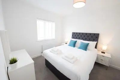 a bedroom with a large white bed with blue pillows at House -Superking Beds-Garden-FastWifi-Pet Friendly in Broomfield