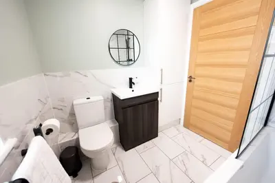 a bathroom with a toilet and a sink and a mirror at 6 The Royal Serviced Apartments, Harwich - Fast WiFi, Private Parking in Parkeston