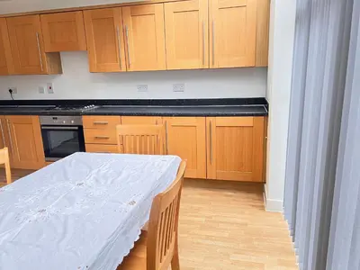 a kitchen with a table with a white sheet on it at 4 Bedroom House Colchester in Colchester
