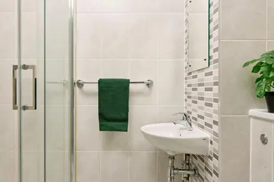 a bathroom with a sink and a shower with a green towel at For Students Only - The Maltings in Colchester in Colchester