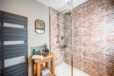 a bathroom with a sink and a brick wall at Market View, Framlingham in Framlingham